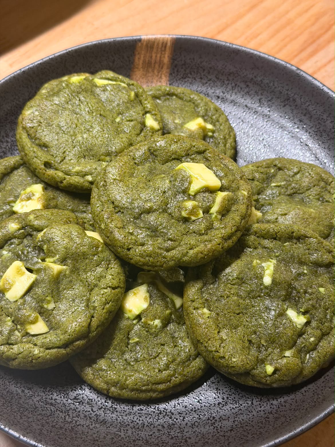 Matcha white chocolate cookies served on a dark ceramic plate